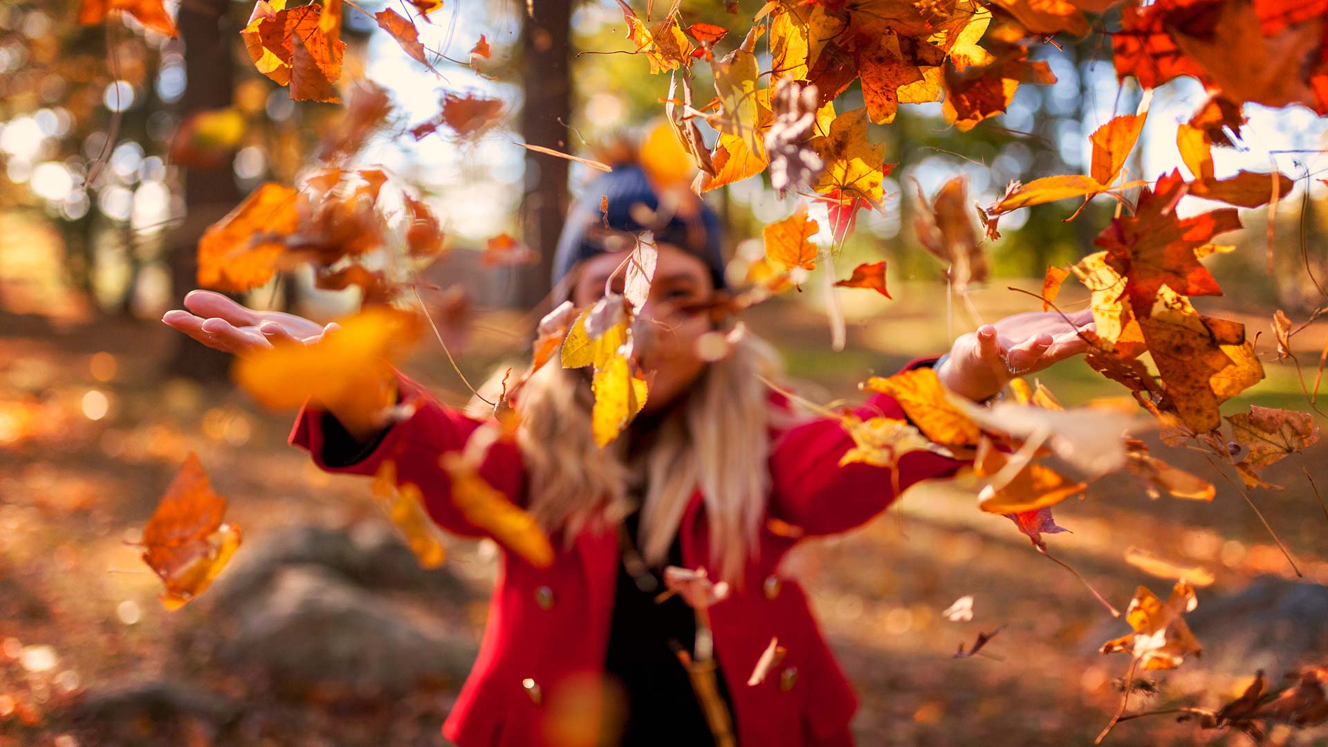 Pige kaster blade op i luften